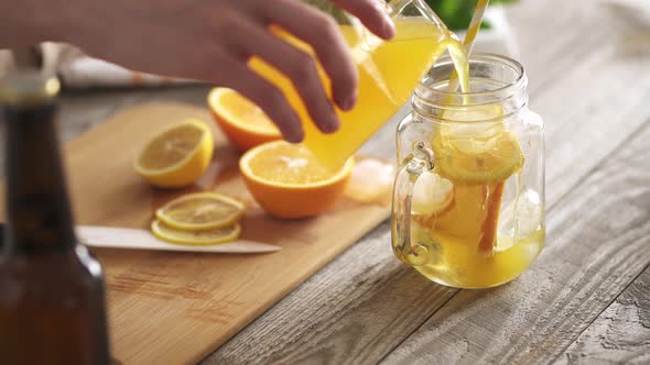 The Hostess Prepares Summer Soft Drinks, Cold Sweet And Sour Orange Juice Is Poured Into A Glass