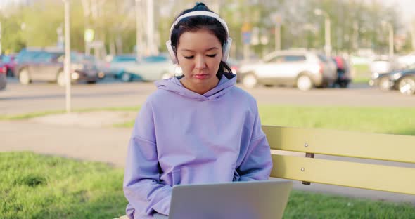 Asian Woman Freelancer Outdoors Working on Laptop