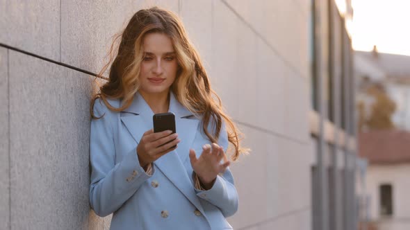 Caucasian Successful Business Woman Young Girl Standing Outdoors in City with Mobile Phone Online