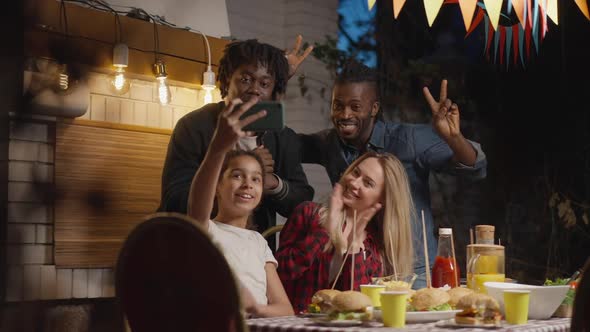 Happy Multinational Men and Woman Making Faces As Teenage Girl Taking Selfie with Family and Friends