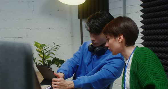 A Man and Woman Work Sitting at One Work Desk in a Office