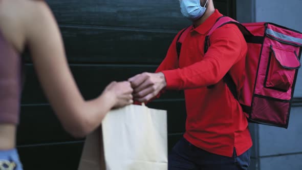 Rider man delivering meal to customers with electric scooter while wearing face mask