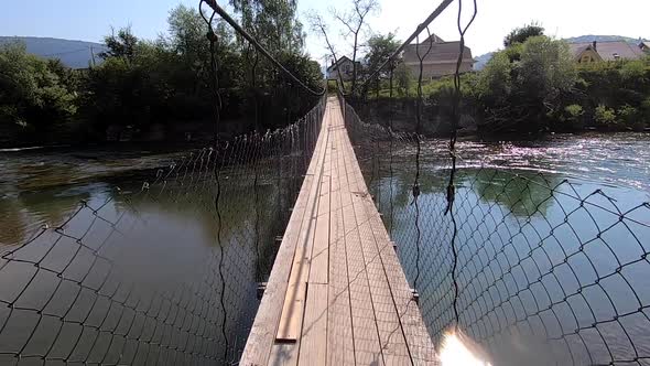 Man Walking Suspension Bridge Over River