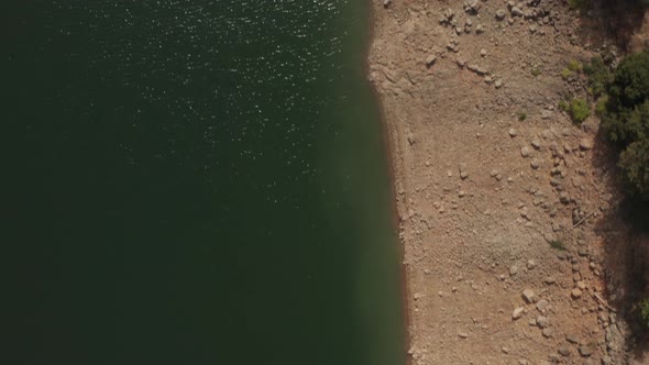 Aerial view of Shasta Lake straight down looking at the shore and low water level in Northern Califo