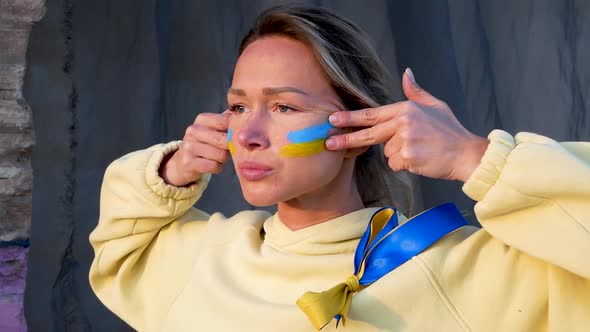 War Portrait of Ukrainian Woman with National Flag on Cheek Crying