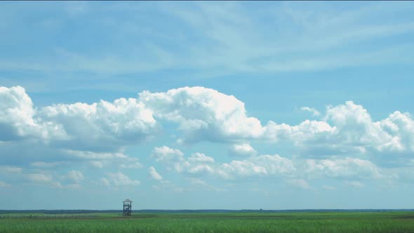 Time lapse of beautiful white fasting clouds and sky in sunny day at lake Liepaja birdwatching tower