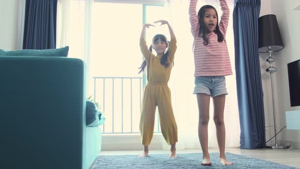 asian female children siblings having fun together in the living room