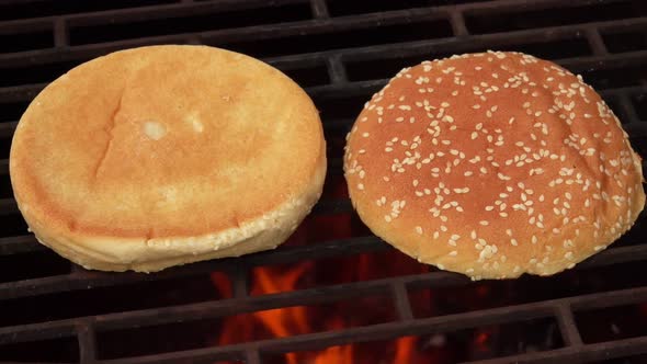 Closeup of Sesame Burger Buns Frying on the Grill Grid Above the Open Fire