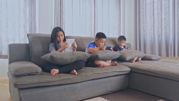 Asian Kids Playing Smartphone On Sofa