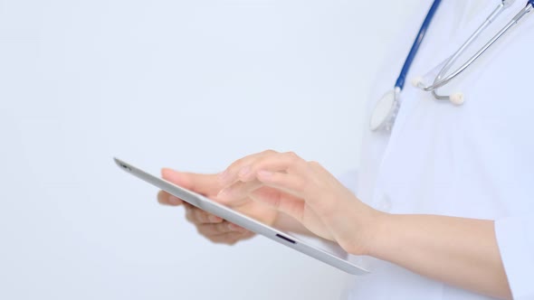 Female Doctor in White Lab Coat Using Modern Digital Tablet Pc