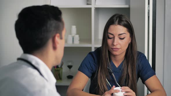 Female and Male Doctors are Communicating in Office of Clinic Therapist and Surgeon are Discussing