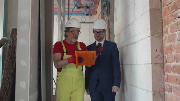 Construction Manager with Worker Checking on Site Using Tablet