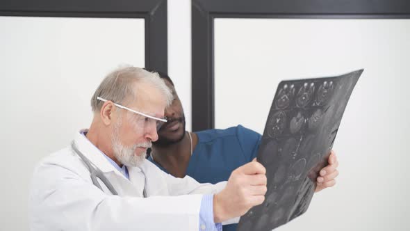 Two Doctors Looking At Computed Tomography Xray Image Discussing