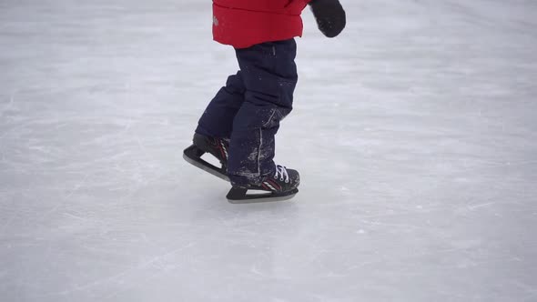 Young Mom and a Little Boy on a Rink. Little Boy Learn How To Ice-skate. Winter Activities Concept