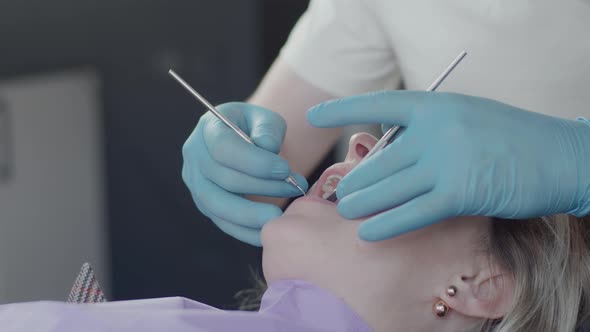 Dentist in protective mask and medical gloves, serve the patient at the dental clinic