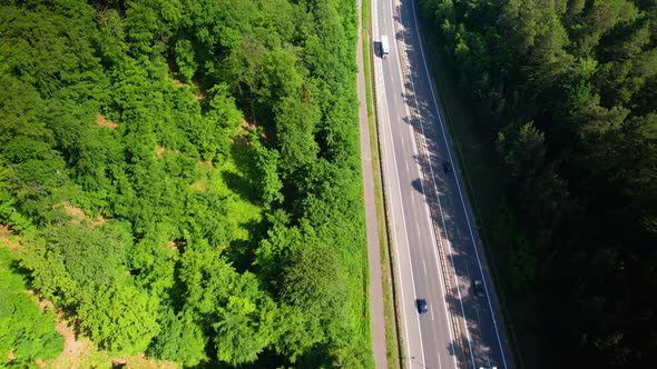 Cars and Vehicles passing on Multi Lane Highway, Forest and trees on both sides