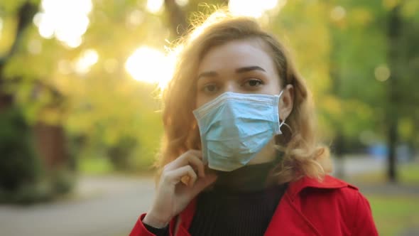 Woman Take Off Surgical Mask in a Park