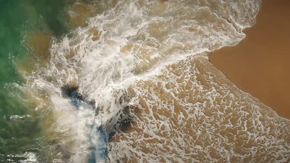 View from the top as ocean waves break on the beach