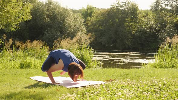 Yoga fail. Female attempting doing crane or crow yoga pose and falling down