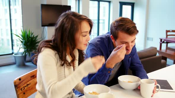 Couple interacting while having breakfast in living room