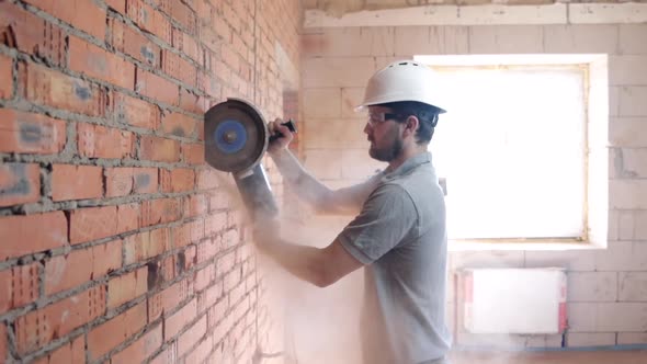 A construction worker with a circular saw in construction site.