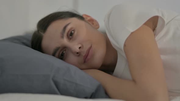 Hispanic Woman Awake in Bed Thinking, Side Pose