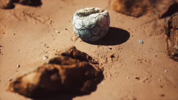 Old Football Ball on the Sand Beach