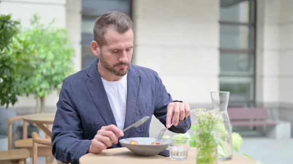 Man Having Lunch While Sitting in Sitting in Outdoor Cafe