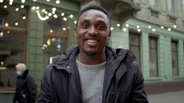 Cheerful Black Guy Stands On The Street And Actively Tells And Shows Something With Hand Gestures