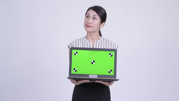 Happy Beautiful Asian Businesswoman Thinking While Showing Laptop