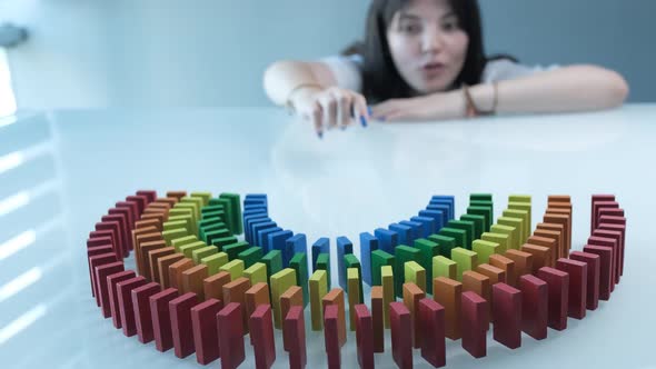 Line up of Dominoes in Rainbow Falling Colors with LGBT Colors of a Hand