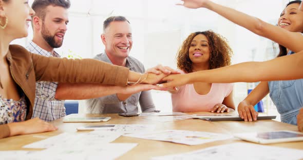 Group of happy colleagues forming hand stack