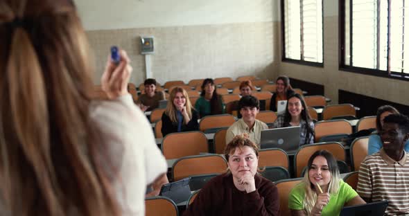 Mature teacher working with students inside classroom at school university