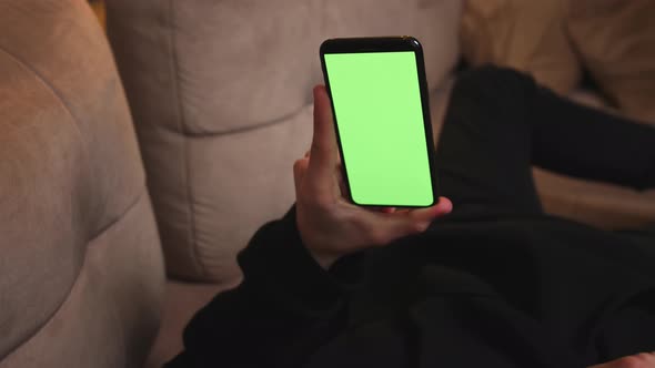 Man at Home Lying on a Couch using Smartphone