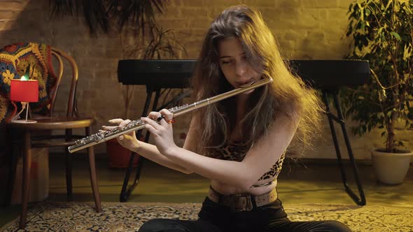 Zoom in Portrait of Young Cute Woman Musician Rehearsing Music Performance at Home Playing Flute