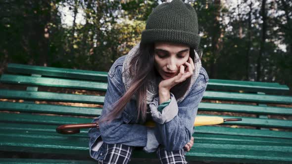 Teenage Girl Yawning Sitting on the Bench in the Park