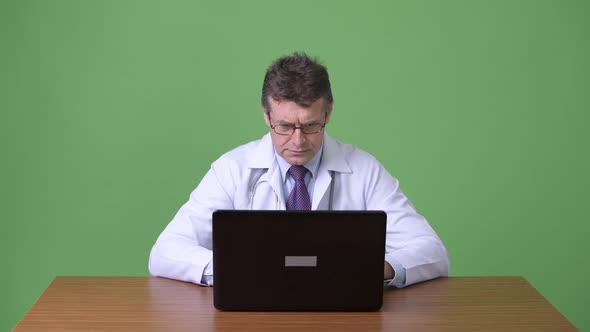 Mature Handsome Man Doctor Against Green Background