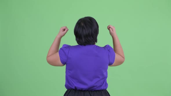 Rear View of Happy Young Overweight Asian Woman with Fists Raised