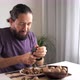 Young Bearded Man Is Cracking and Eating a Walnuts at Domestic Room - VideoHive Item for Sale