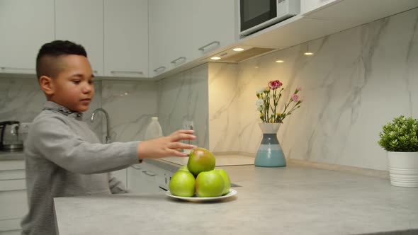 Carefree Black Boy Taking Fruit Biting Off Apple Smiling Indoors