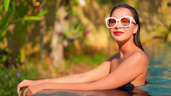 Young asian woman enjoy around outdoor swimming pool for leisure