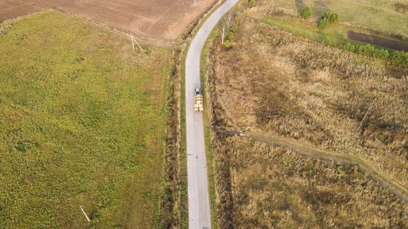 On the Way a Tractor Loaded with Bales of Hay Aerial View