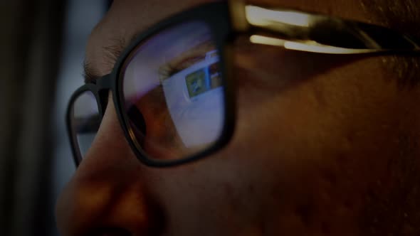 Closeup of a Man in Glasses Working at a Computer at Night