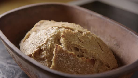 BAKING - Uncovering sourdough bread fresh from the oven, slow motion close up