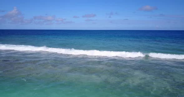 Natural fly over copy space shot of a white paradise beach and aqua blue water background in vibrant