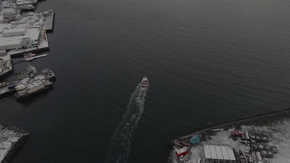 Fishing boat leaving harbour towards the fishing grounds of the Arctic, aerial