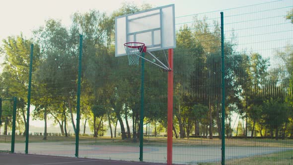 Basketball Player Slam Dunking on Outdoor Court