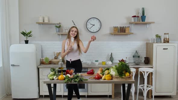 Happy Vegan Girl with Slim Waist Dancing, Singing in Kitchen. Raw Vegetable Nutrition Diet Concept