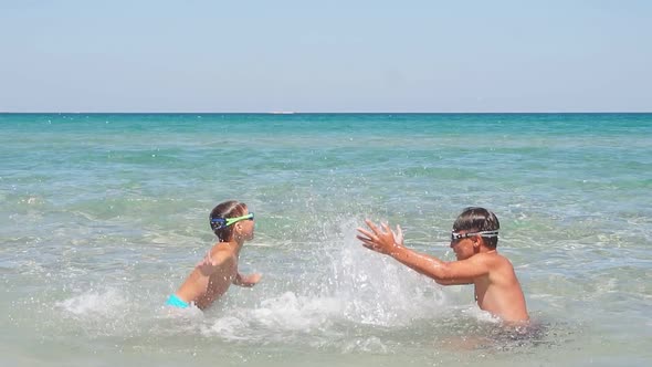 Children Boys Play in the Azure Turquoise Sea on a Sunny Day Creating a Splash of Water