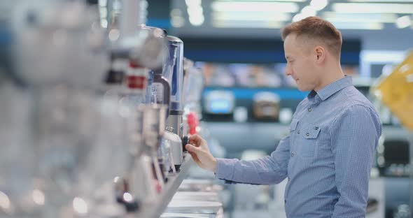 In the Appliances Store, the Kitchen Technician Chooses the Blender in His Hands